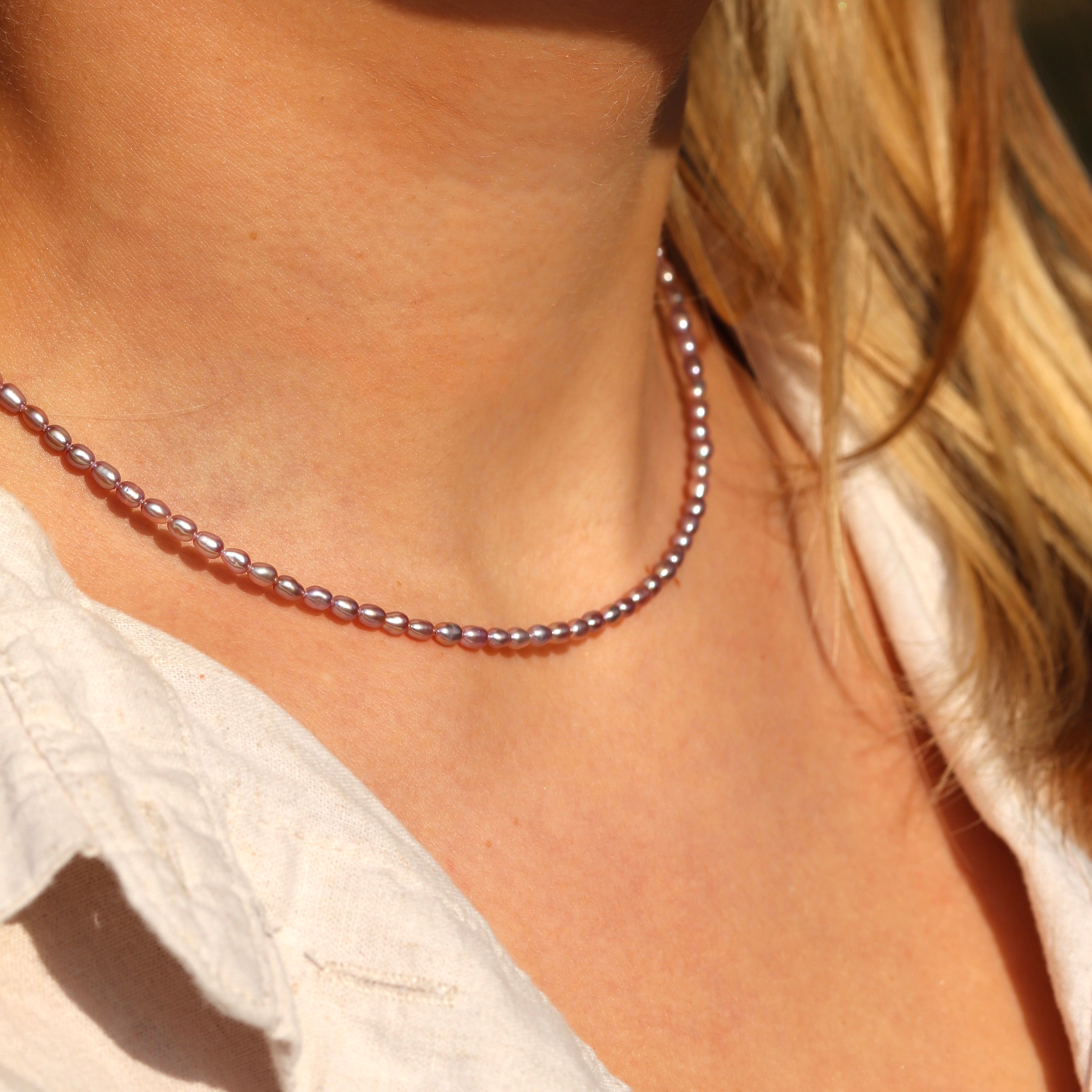 Elegant rose freshwater pearl necklace styled with outfit flat lay, feminine jewelry gift for her or bridal wear.