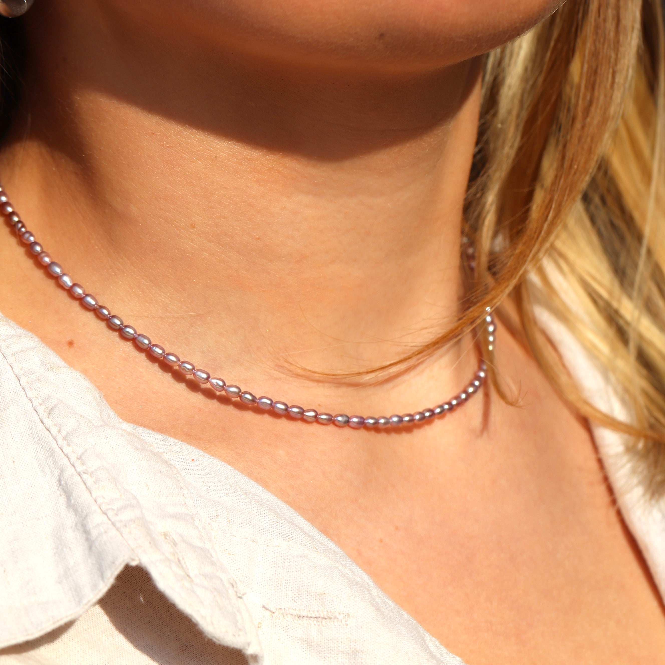 Woman wearing dainty rose pink freshwater pearl necklace, minimalist jewelry gift for her or everyday wear.