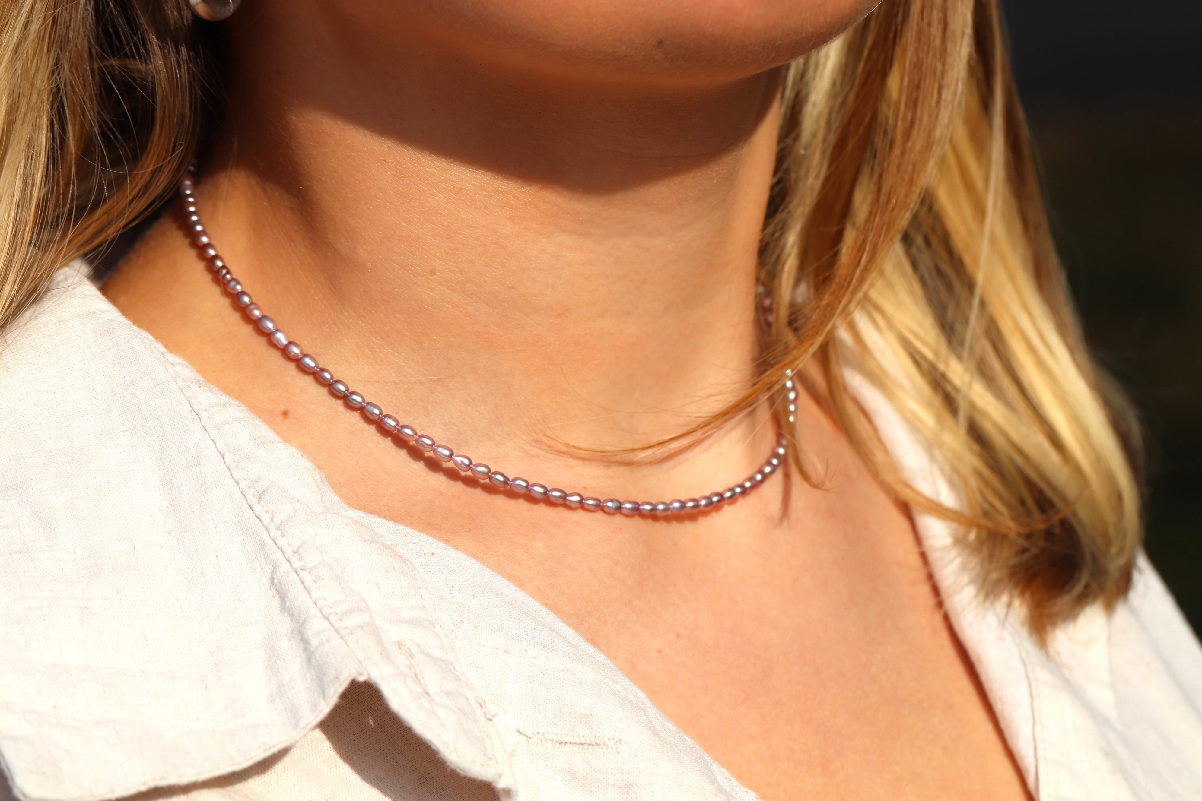 Woman wearing dainty rose pink freshwater pearl necklace, minimalist jewelry gift for her or everyday wear.